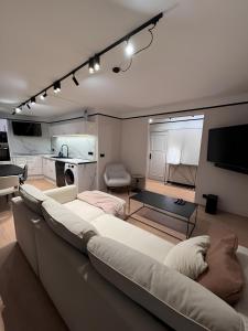 un soggiorno con un grande divano e una cucina di Appartement Hyper-Centre Megeve - ski à pied a Megève