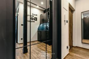 a hallway with a glass door leading to a bathroom at Happy Nest - Happy Apartamenty Mielec in Mielec