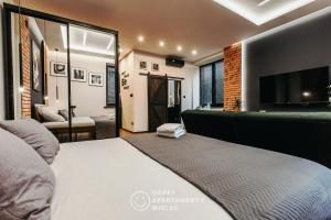 a bedroom with a bed and a flat screen tv at Happy Nest - Apartamenty Happy Mielec in Mielec