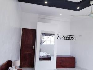 Habitación blanca con puerta y espejo en Appartement moderne K WhiteRed à pk10, Cotonou, en Cotonou