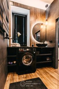 ein Badezimmer mit einer Waschmaschine und einem Waschbecken in der Unterkunft Happy Nest - Happy Apartamenty Mielec in Mielec