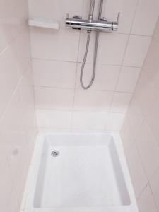 a white tub in a bathroom with a shower at Appartement moderne K WhiteRed à pk10, Cotonou in Cotonou