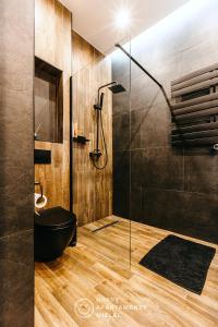 a bathroom with a shower and a black tub at Happy Nest - Happy Apartamenty Mielec in Mielec
