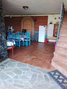Pokój ze stołem i niebieskimi krzesłami oraz lodówką w obiekcie VILLA MIMOSA Splendida Vista Mare w mieście Bonassola