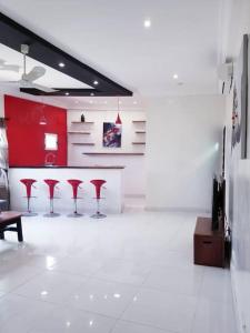 una cocina con taburetes rojos en una habitación blanca en Appartement moderne K WhiteRed à pk10, Cotonou, en Cotonou