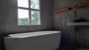 a white bath tub in a bathroom with a window at Dins Nature Villa in Elgiriya