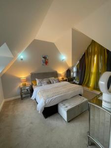 Luxurious Five-Bedroom Haven في Long Stanton: غرفة نوم بسرير كبير وستائر صفراء