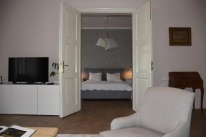 een slaapkamer met een bed, een stoel en een televisie bij Center Marvel in Ljubljana