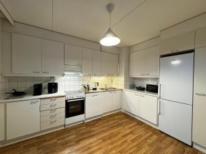 uma cozinha com armários brancos e um frigorífico em DownTown Rooms And Sauna em Helsinque