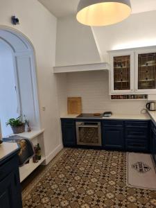 una cucina con armadi blu e pavimento piastrellato di Maison de charme - accès autonome a Orléans