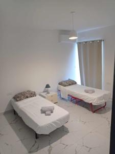 una camera con due letti e una lampada di Poppy Court a Marsaskala