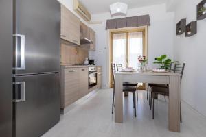a kitchen with a table with chairs and a refrigerator at Medea home in Catania