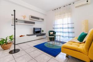 a living room with a yellow couch and a tv at Medea home in Catania