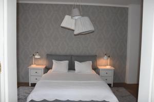 een slaapkamer met een wit bed en 2 nachtkastjes bij Center Marvel in Ljubljana