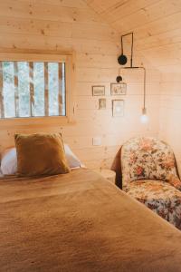 a bedroom with a bed and a chair at Cabane de la Saône by Lyon Country House in Caluire-et-Cuire