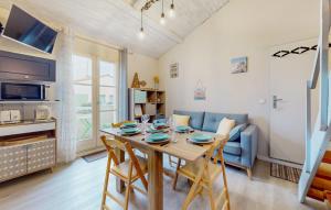 eine Küche und ein Wohnzimmer mit einem Tisch und einer Couch in der Unterkunft Appartement Aloha Ohana 4-6 personnes à 400m de la plage à Dolus d'Oléron in Dolus d'Oléron