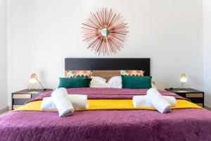 a bedroom with a large bed with purple and yellow sheets at Medea home in Catania