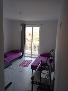 a room with two beds and a window at Poppy Court in Marsaskala