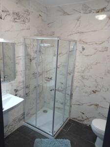a bathroom with a shower with a toilet and a sink at Poppy Court in Marsaskala