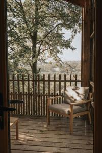 a chair sitting on the porch of a cabin at La cabane de la Saone, Lyon Country house in Caluire-et-Cuire