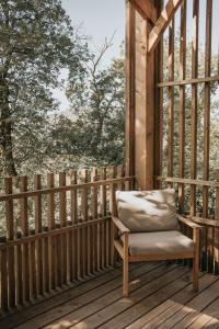 a chair sitting on a porch with a window at Cabane de la Saône by Lyon Country House in Caluire-et-Cuire