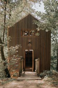 un edificio de madera con una puerta en un bosque en La cabane de la Saone, Lyon Country house en Caluire-et-Cuire