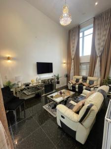 Luxurious Five-Bedroom Haven في Long Stanton: غرفة معيشة مع أريكة وتلفزيون