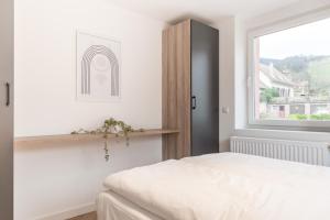 a bedroom with a white bed and a window at Adler Apartments Sasbachwalden in Sasbachwalden