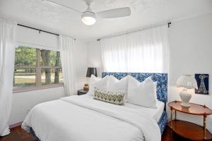 a bedroom with a large white bed and a window at Baron's Bungalow with hot tub & pet friendly in Fredericksburg