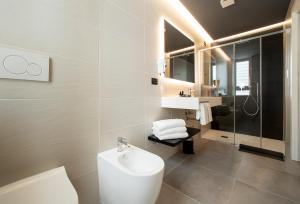 La salle de bains est pourvue de toilettes, d'un lavabo et d'une douche. dans l'établissement Hotel Sayonara, à Lido di Jesolo