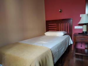 1 dormitorio con 2 camas y mesa con lámpara en Hotel Cabo Ortegal, en Cariño