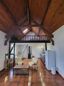 una gran sala de estar con techo de madera. en Cottage du Diot, son lac et son île en Bannegon