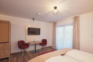 貝曼廷根的住宿－佐拉斯度班酒店，卧室配有一张床和一张桌子及椅子