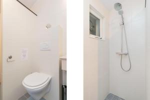 a white bathroom with a toilet and a shower at Eysingastate in Rinsumageest