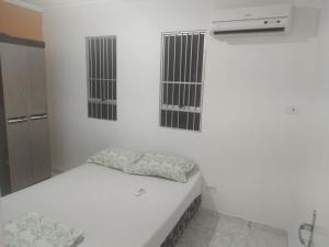 Habitación blanca con cama y aire acondicionado en Temporada em Aracaju, en Aracaju 4 fotos más