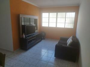 Una sala de estar con televisión y un sofá. en Temporada em Aracaju, en Aracaju