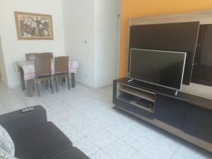 Una sala de estar con un televisor de pantalla plana grande. en Temporada em Aracaju, en Aracaju