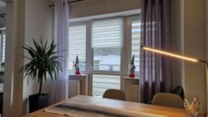 a dining room with a table and a large window at Apartament Gwiazda 303 in Krynica Zdrój