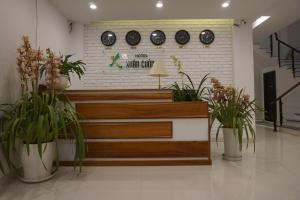 a store with potted plants and clocks on the wall at Xuan Cuong Hotel in Da Lat