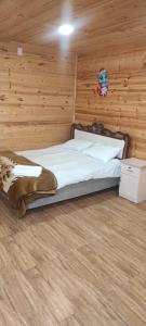 Ce lit se trouve dans un dortoir doté d'un mur en bois. dans l'établissement NAREK B&B, à Goris