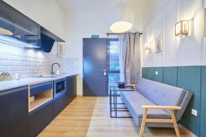 een keuken met een blauwe bank en een tafel bij Madrid Urban Comfort in Madrid