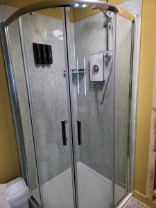 a shower with a glass door in a bathroom at THE MOORINGS in Broadford