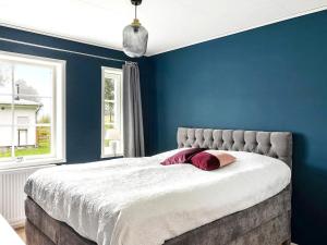 a bedroom with blue walls and a large bed at 4 person holiday home in NORRTÄLJE-By Traum in Norrtälje