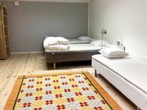 セルヴェスボリにあるHoliday home SÖLVESBORG XIIのベッド2台とラグが備わる客室です。