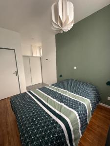 Schlafzimmer mit einem Bett und einem Kronleuchter in der Unterkunft Maison Cosy in Lourdes