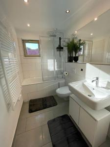 a white bathroom with a sink and a toilet at LIGHTPLACE • Moderne Innenstadt-Wohnung • Balkon zur Oker in Braunschweig