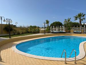 a large swimming pool with blue water in a resort at Quinta Nova Vale Del Rey in Carvoeiro