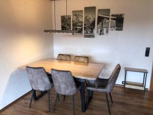 上斯陶芬的住宿－Schöne 2 1/2 Zimmer Ferienwohnung in Oberstaufen - Hoamatle -，一间带木桌和椅子的用餐室