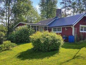a red house with a solar roof on a yard at Holiday home SÖDERALA in Söderala