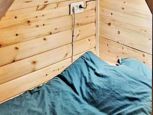 a bed in a room with a wooden wall at Holiday home Bureå in Bureå